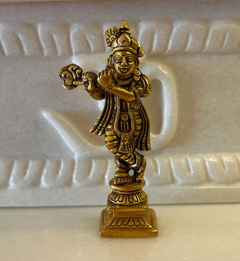 This 4” idol of Lord Krishna immersed in playing his flute is captivatingly charming