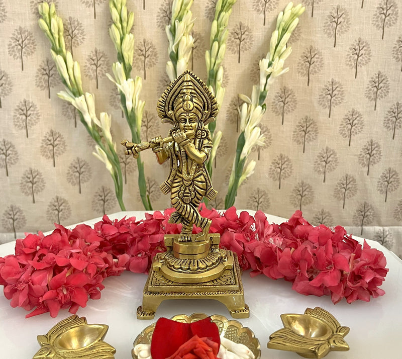 This exquisitely carved 6-inch brass statue depicts Lord Krishna in his iconic form playing the flute