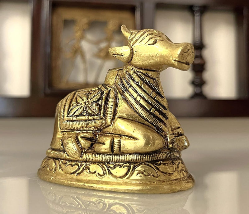 This small brass Nandi statue is a charming representation of the sacred bull, revered as the vahana (vehicle) of Lord Shiva