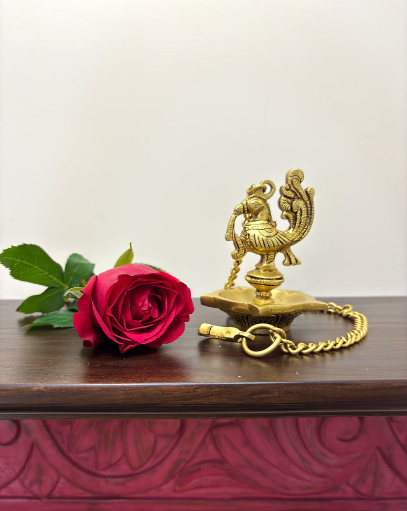 The simple 5 wick diya with a beautifully crafted Annapakshi adds a touch of elegance to its functionality.